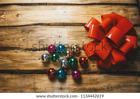 holiday image. big red bow on a brown wooden background. photo for the new year with Christmas balls and a gift bow. new year, holiday, christmas