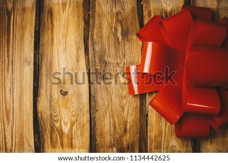 holiday image. big red bow on a brown wooden background. photo for the new year with Christmas balls and a gift bow. new year, holiday, christmas