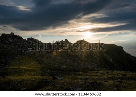 The panoramic mountain view with rocks and ice in Tian Shan mountains in Central Asia near Almaty covered by dramatic sunset clouds. Best place for active life, climbing, hiking and trekking.