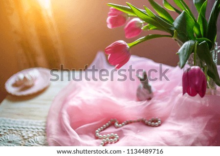 pink tulips in a vase are on the wall near the window soft focus and sunlight