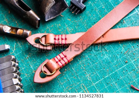 Genuine vegetble tanned leather of camera strap with tool on crafts working