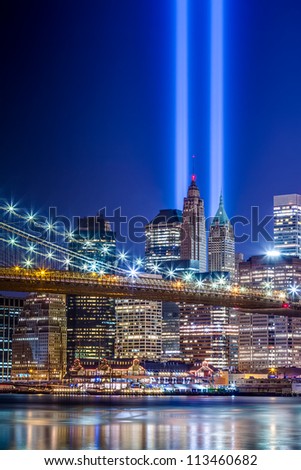 911 Lights over New York City - beautiful HDR image of September 11th commemoration beams over Brooklyn Bridge with Manhattan skyscrapers at night