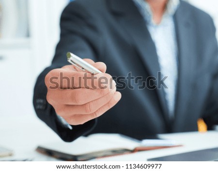 Male arm in suit offer silver pen to sign contract closeup. Strike a bargain for profit, white collar motivation, union decision, corporate sale, insurance agent concept