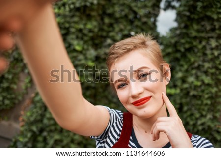   woman taking pictures of herself in the park                             