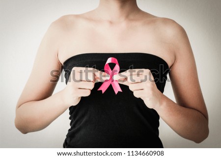 healthcare and medicine concept. Woman hand holding pink breast cancer awareness ribbon.