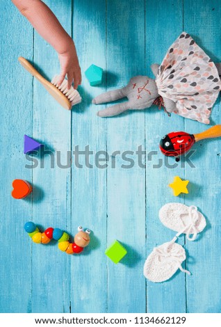 baby hand catch the toy - childhood background at blue wooden table