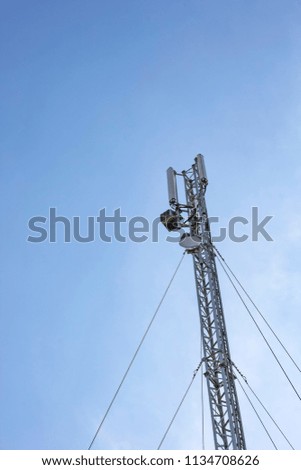 Antenna cellular tower and blue sky. Vertical view