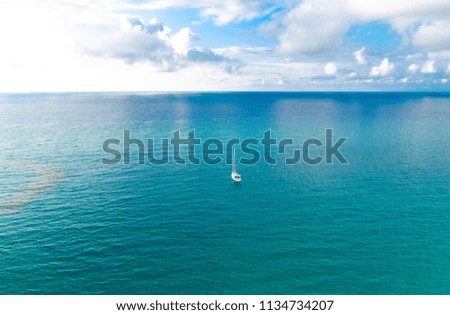 Aerial view of beautiful amazing Tyrrhenian sea with turquoise water, tropical seascape, endless horizon with bright blue sky and white clouds, small yacht background, Tropea, Calabria, Southern Italy