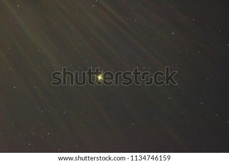 light of a bright star against a background of small stars makes its way through floating clouds, photo of space
