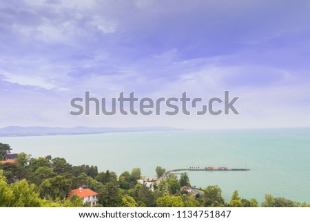 Calm water landscape with a pier under the blue sky