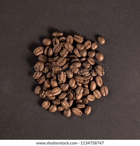 Pile of coffee beans on a black paper background