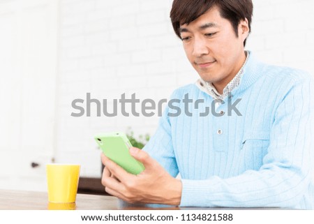 Asian middle age man who uses smart phone