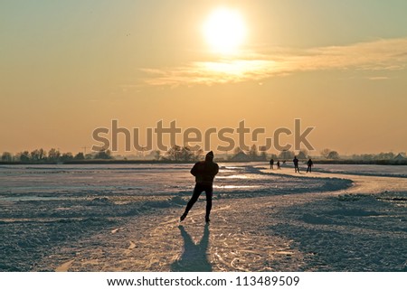 Ice skating in the countryside from the Netherlands at sunset