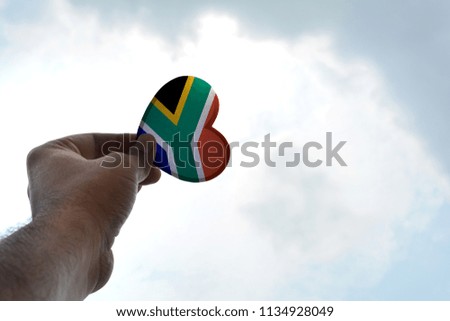 Hand holds a heart Shape South Africa flag