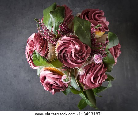 Bouquet of cupcake and green leaves in a black flowerpot. Dark background. A gift to the girl