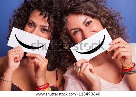 Two Young Women with Smiley Emoticon on Blue Background