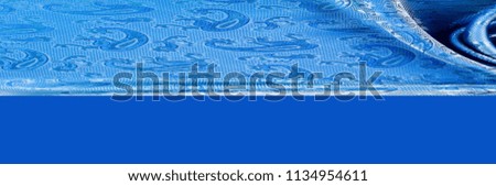 The texture of the silk fabric. Dark blue. With a picture of cucumbers. a fine, strong, soft, lustrous fiber produced by silkworms in making cocoons and collected to make thread and fabric