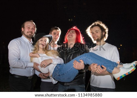 Group of friends having fun together outdoor in a night and light behind them
