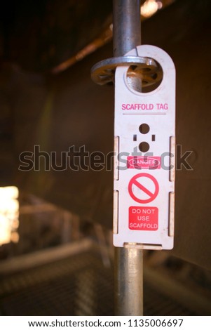 Incomplete scaffolding sign tag hanging on the scaffold tube danger warning do not use 