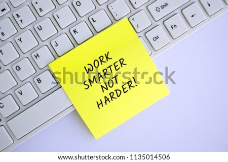 Inspirational and motivation life quote on paper note attached to keyboard - Work harder not smarter. 