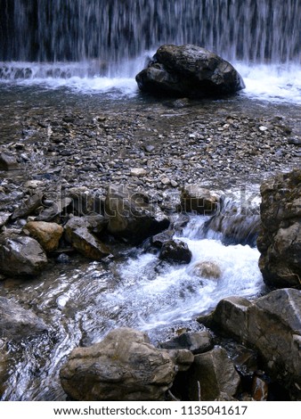 Mountain stream with waterfall and wet rock and Stones,