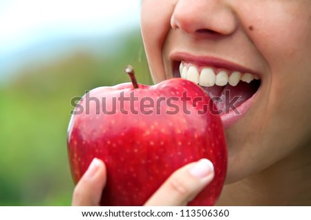 Biting an apple Royalty-Free Stock Photo #113506360