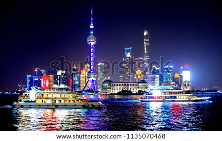 colorful lights and futuristic skyline and boats on river of shanghai pudong skyscrapers, China