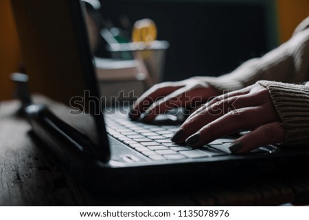 Close up of woman's hands typing on laptop keyboard, vintage color tone