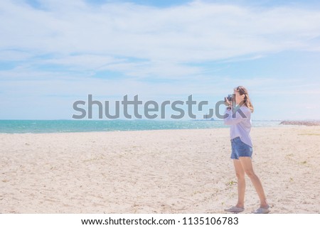 Woman traveler taking a photo at the beach, Beautiful and enjoy view.
