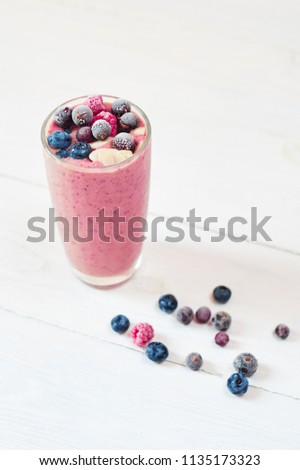 Glass of pink fruit smoothies milkshake or cocktail on white background, breakfast vegan and raw food, with a place for your text