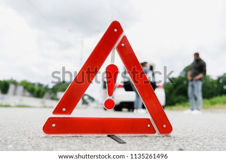 man and woman standing on road with red stop sign on foreground