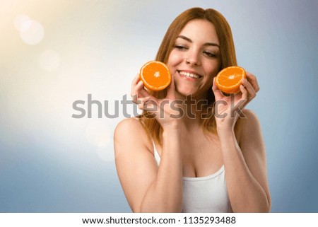 Beautiful young girl holding an orange juice on unfocused background