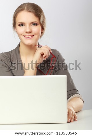 A young woman with a laptop sitting isolated on white background