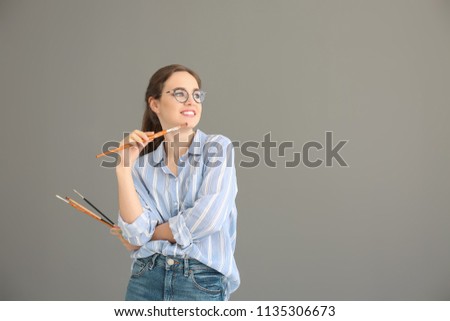 Portrait of female artist on grey background