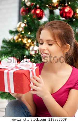 bright picture of happy woman with gift box and christmas tree......