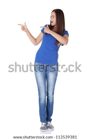 Happy , excited young woman pointing on copy space, isolated on white