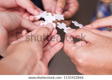 Many business colleagues is putting part of jigsaws together represents collaboration of  the team work is the key to success. Royalty-Free Stock Photo #1135422866