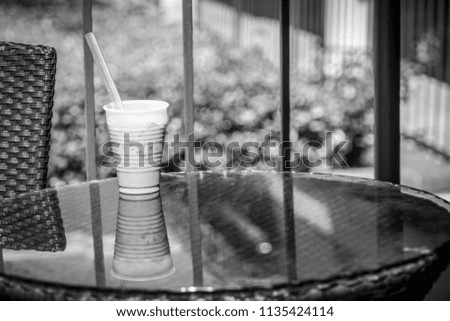Iced coffee urban modern living a refreshing drink of caffeine and tasty mocha goodness in a black and white finish mirrored reflection off glass patio table