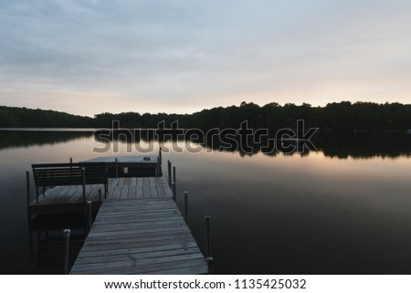 Wooden dock and a bench on a quiet lake