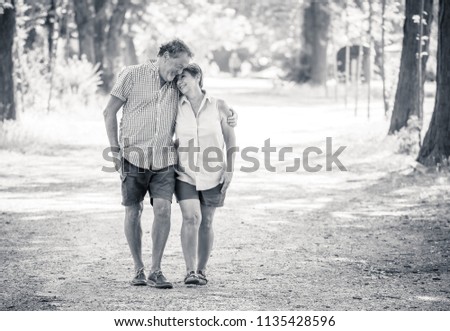 Happy beautiful senior couple in love walking and holding hands in the park enjoying life outdoors. Happy and active retirement concept