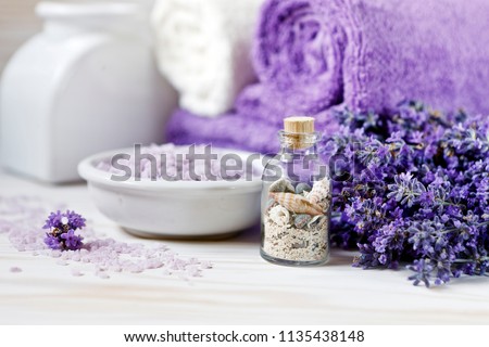 Lavender flowers, aromatic sea salt and towels. Concept for spa, beauty and health salon, cosmetics store. Natural cosmetics. Close up photo on white wooden background.