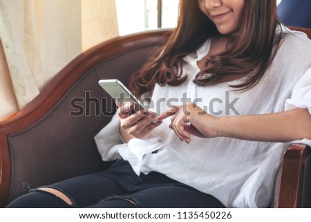 Closeup image of an asian woman holding , using and touching a smart phone