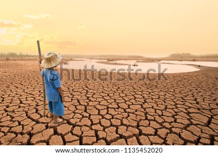 Climate change and World environmental concept. Children looking at drying river after Drought impact on summer. Royalty-Free Stock Photo #1135452020