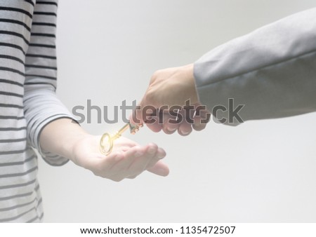 Close up hand of businessman giving golden key to hand of woman, Key of success concept.