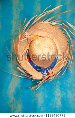 Straw hat, Junina party ornament. Blue background.