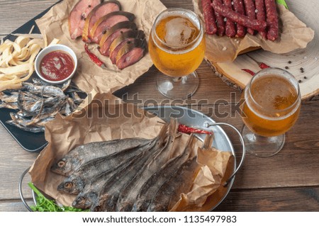 Dried fish and beer snacks on an old wooden table. Top view.