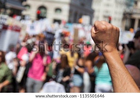 A raised fist of a protestor at a political demonstration Royalty-Free Stock Photo #1135501646