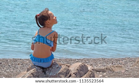 child breathes the sea air, enjoys nature