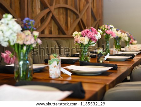 Beautiful Interior Restaurant Dining Table Setting with Romantic Floral Arrangement and Wood Table