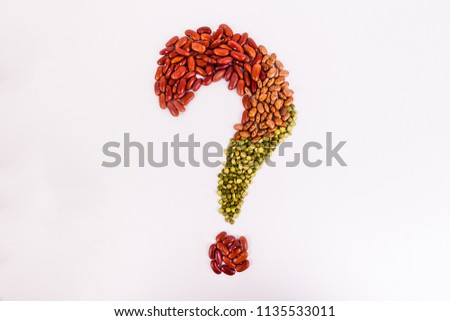 Question mark shaped out of pinto red kidney lentil beans on solid white background 